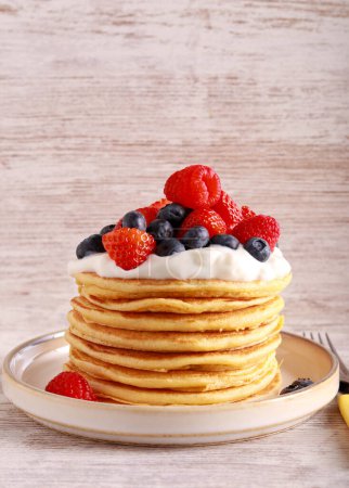 Photo for Pile of pancakes with yogurt and mix berry topping - Royalty Free Image