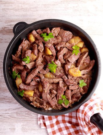 Foto de Beef liver and apples stew in a pan - Imagen libre de derechos