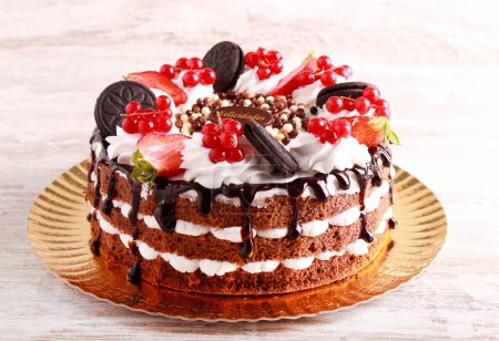 Photo for Chocolate layered cake with fruit and berry decoration - Royalty Free Image