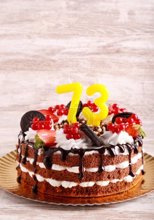 Foto de Pastel de cumpleaños de chocolate, con velas setenta y tres en él - Imagen libre de derechos