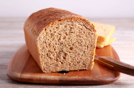 Photo for Whole wheat and flax bread on wooden board - Royalty Free Image