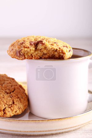 Photo for Oatmeal cookies with chocolate chunks and nuts, served with black coffee - Royalty Free Image