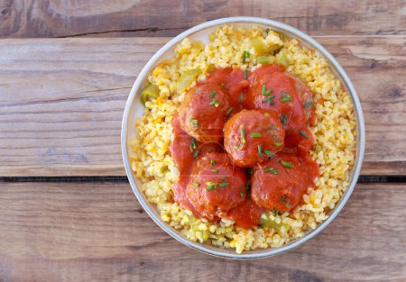 Photo for Bulgur with vegetables and meatballs in tomato sauce - Royalty Free Image