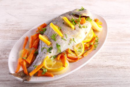 Photo for Baked dorada sea bream fish with lemon and carrot - Royalty Free Image