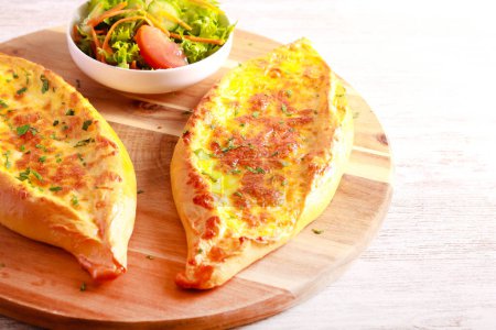 Téléchargez les photos : Bateau à fromage, pain croûté au fromage fondu sur planche de bois - en image libre de droit