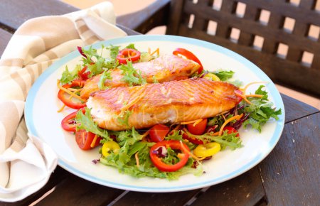 Photo for Fried salmon fillets over salad - Royalty Free Image