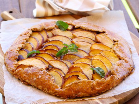 Photo for Whole meal peach galette cake on wooden board - Royalty Free Image