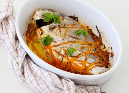 Photo for Baked dorado fish with carrot in a tin - Royalty Free Image
