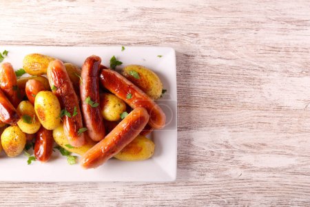 Photo for Roast sausages and potatoes on plate - Royalty Free Image