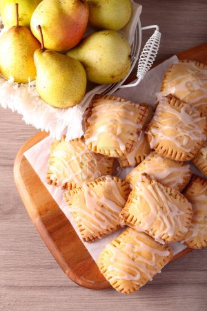 Photo for Pear and cinnamon hand pies on wooden board - Royalty Free Image