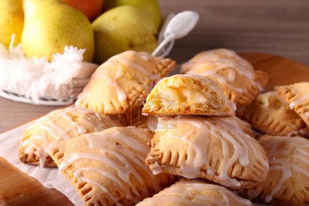 Photo for Pear and cinnamon hand pies on wooden board - Royalty Free Image