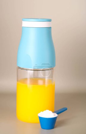 Téléchargez les photos : Complément de poudre monohydrate de créatine pour athlètes et bouteille de jus d'orange - en image libre de droit