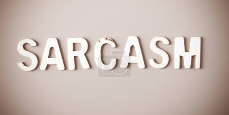 Word - Sarcasm - written with wooden letters