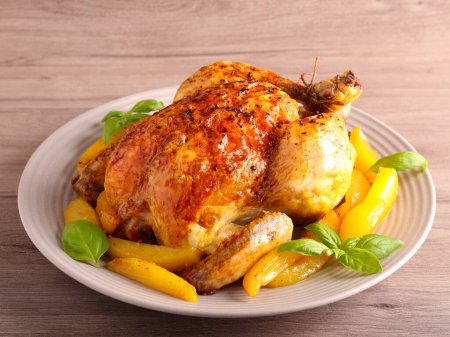 Photo for Roast whole chicken with potatoes on plate - Royalty Free Image