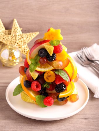 Photo for Fruit and berry Christmas tree. Healthy dessert made of fresh raw fruits in shape of Christmas tree. - Royalty Free Image