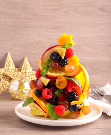 Photo for Fruit and berry Christmas tree. Healthy dessert made of fresh raw fruits in shape of Christmas tree. - Royalty Free Image
