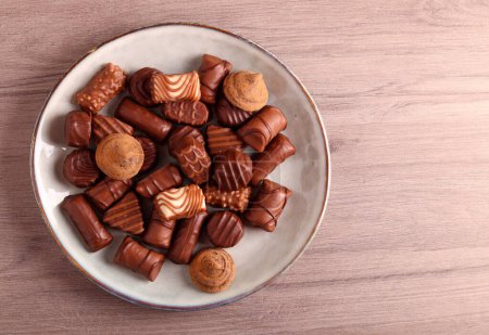 Photo for Selection of assorted chocolate sweets on plate - Royalty Free Image