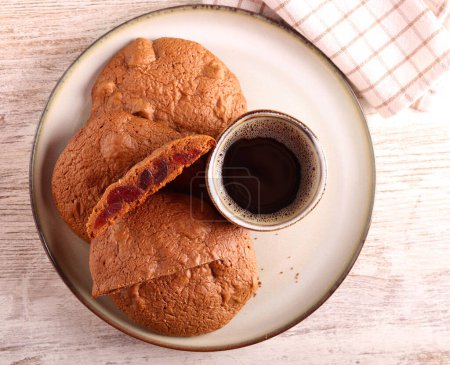 Photo for Chocolate cookies with cranberry on plate with coffee - Royalty Free Image