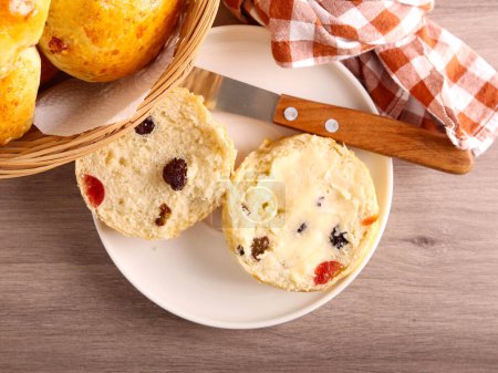Photo for Sweet bun half with raisin and cherries and butter over - Royalty Free Image