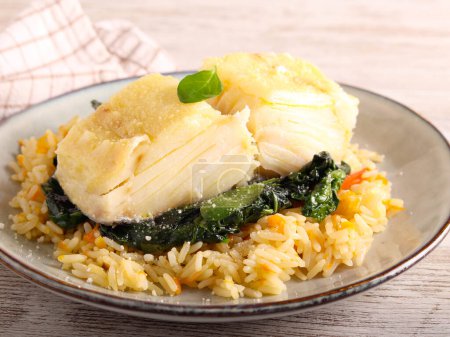 Foto de Filete de bacalao con cobertura de parmesano sobre espinacas y arroz - Imagen libre de derechos