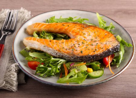 Téléchargez les photos : Steak de saumon frit sur salade - en image libre de droit
