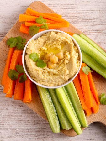 Photo for Fresh homemade hummus with carrots and cucumbers - Royalty Free Image