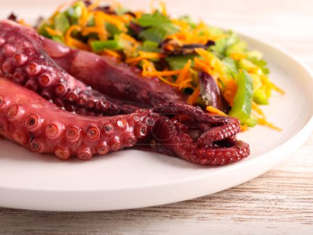 Foto de Tentáculos de pulpo cocidos con ensalada en plato - Imagen libre de derechos