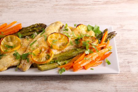 Photo for Lemon fish with asparagus and carrot on plate - Royalty Free Image