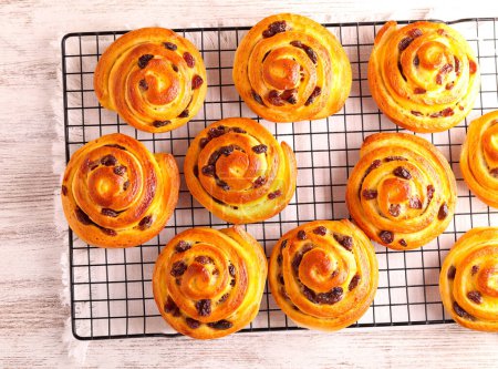 Photo for Custard cream and raisin buns on rack - Royalty Free Image