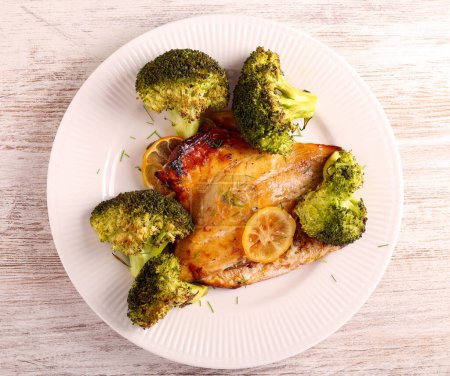Photo for Lemon dorada fish with broccoli on plate - Royalty Free Image