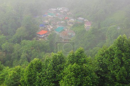 panorama of foggy and cloudy mountain village, on the slopes of himalaya mountains near darjeeling hill station in monsoon season, west bengal, india