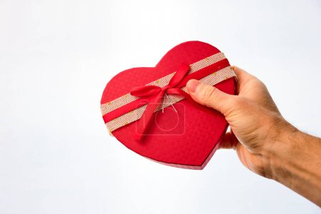 Téléchargez les photos : Gift box in the shape of a red heart on a white background. - en image libre de droit