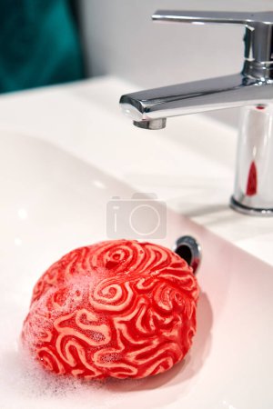 Photo for Foam-Filled Brain under a Sink Faucet, Brainwashing Concept. - Royalty Free Image