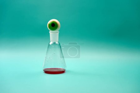 eye prosthesis on top of an Erlenmeyer flask with blood.