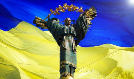 Kiev, Ucrania 20 de julio de 2020: Un monumento dedicado a la independencia de Ucrania en el contexto de la bandera más grande de Ucrania