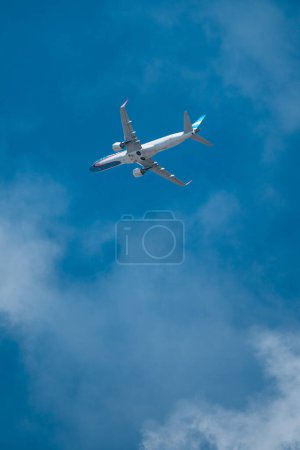 Foto de Airline plane over light blue sky with few clouds.Plane view in full takeoff. - Imagen libre de derechos