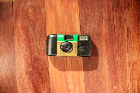 Foto de Fotografía de arriba hacia abajo de la cámara de película desechable simple de un solo uso de Fujifilm en el suelo - Imagen libre de derechos