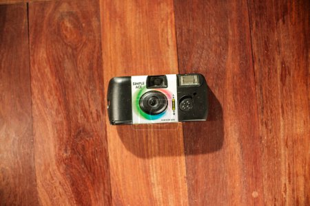 Foto de Fotografía de arriba hacia abajo de la cámara de película desechable simple de un solo uso de Fujifilm en el suelo - Imagen libre de derechos