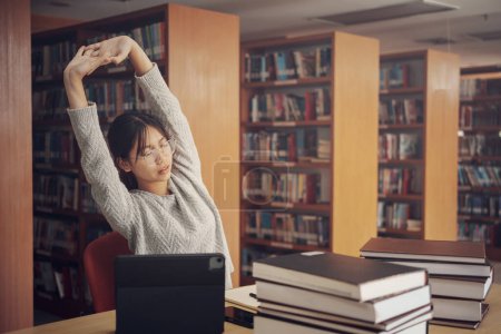 Photo for Student girl reading and doing stretch oneself in library of university or colleage. - Royalty Free Image