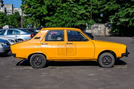 Photo for Bucharest, Romania - 5 June 2021: Old retro vivid yellow orange Romanian Dacia 1300 classic car parked in a street in a sunny summer day - Royalty Free Image