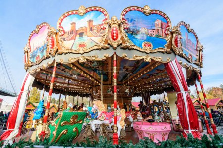 Photo for Bucharest, Romania, 30 November 2023: Vivid colorful carousel at the West Side Christmas Market in Drumul Taberei neignbourhood, in a sunny cold day with blue sky - Royalty Free Image