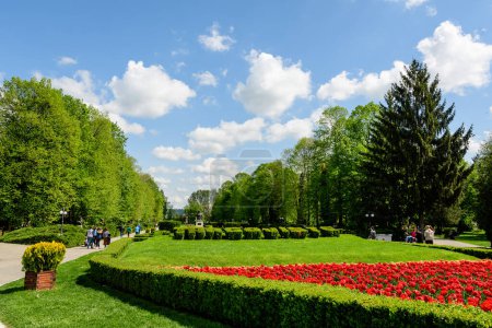 Photo for Targoviste, Romania, 1 May 2022: Landscape with vivid green trees and grass in Chindia Park (Parcul Chindia) in the city center in a sunny spring  day with white clouds and blue sky - Royalty Free Image
