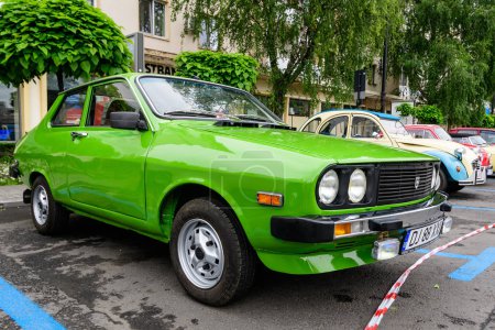Photo for Craiova, Romania, 29 May 2022: Old vivid green Romanian Dacia 1310 classic car produced in year 1987 in a street in the city center, in a sunny spring day - Royalty Free Image