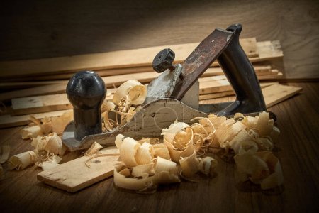 Photo for Planer and shavings after planing wooden boards on the workbench, carpentry, handwork. - Royalty Free Image