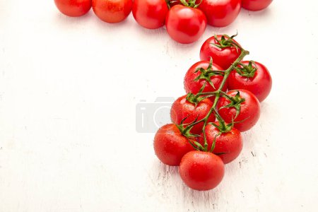 Ripe cherry tomatoes on white wooden background. Close-up of cherry tomatoes