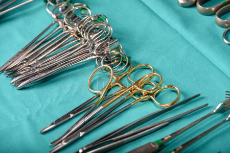 Téléchargez les photos : Préparez-vous pour les instruments chirurgicaux pendant l'opération, ciseaux, pinces et scalpels, ciseaux droits utilisés pour couper le matériau de suture où comme ciseau courbe pour les tissus. Concept de préparation chirurgicale - en image libre de droit