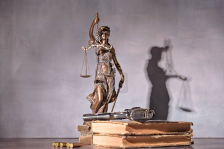 Photo for Gun in the foreground with the background is a representation of justice. Concept of use of arms and justice - Royalty Free Image