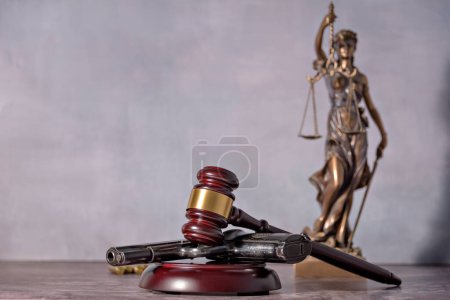 Photo for Gun in the foreground with the background is a representation of justice. Concept of use of arms and justice - Royalty Free Image