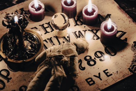 A dark atmospheric setting with an Ouija board, candles, and mystical objects invoking a sense of the occult