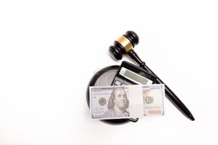 Ein isoliertes Bild eines Richters, der mit einem Taschenrechner auf einen Stapel Bargeld starrt, bedeutet Geldstrafen oder Kaution.